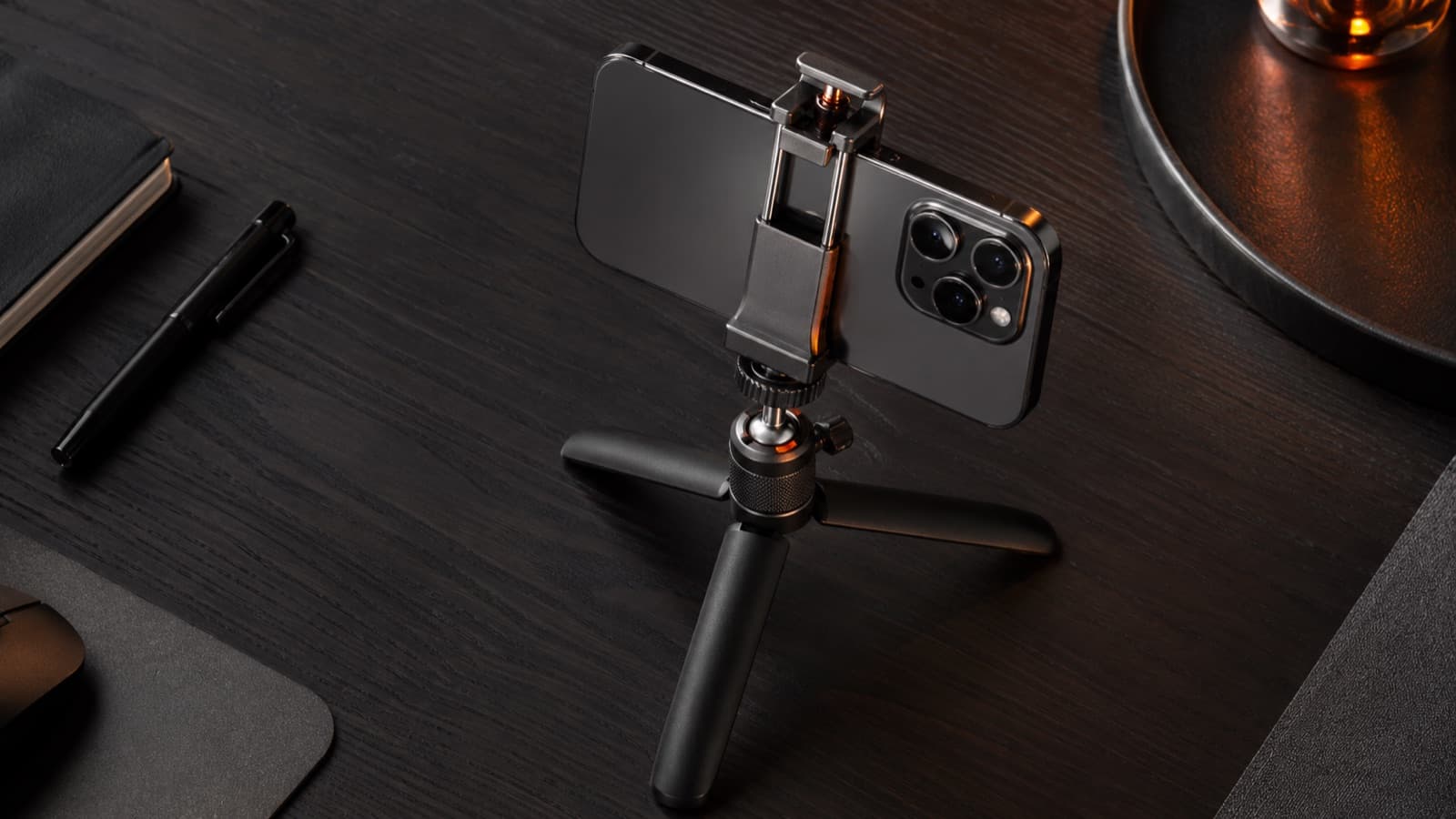 Un mini trípode de mesa con pinza sosteniendo un celular en horizontal