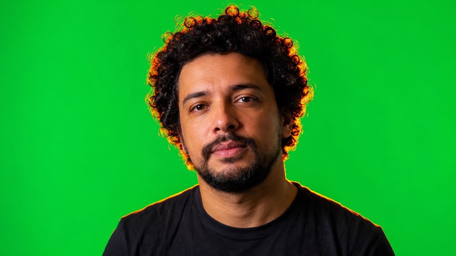 Persona frente al fondo verde con un contraluz naranja recortando el cabello, matando el spill verde en los bordes