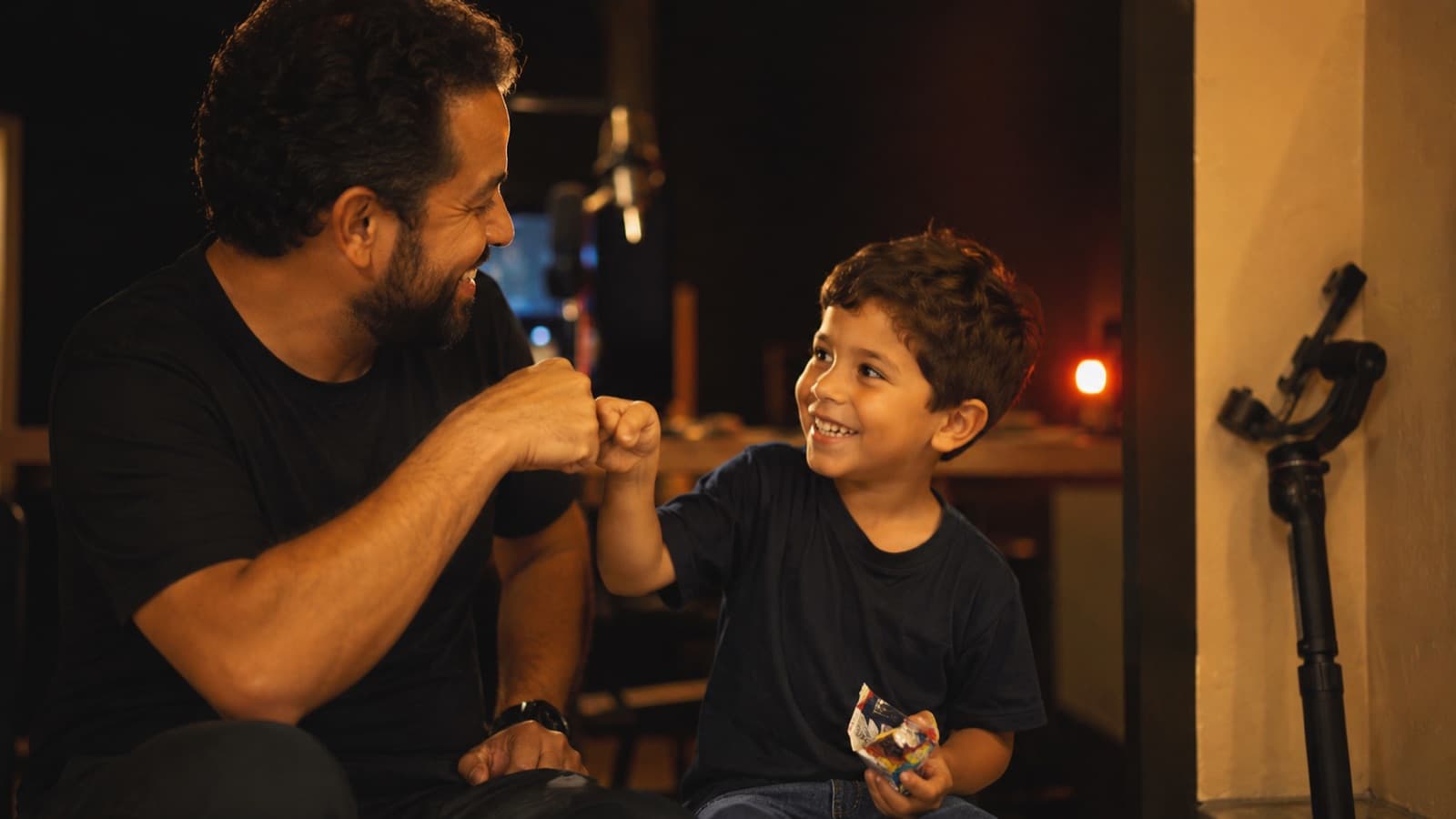 Un adulto celebrando con el niño después de grabar — un choca esos cinco y un premio