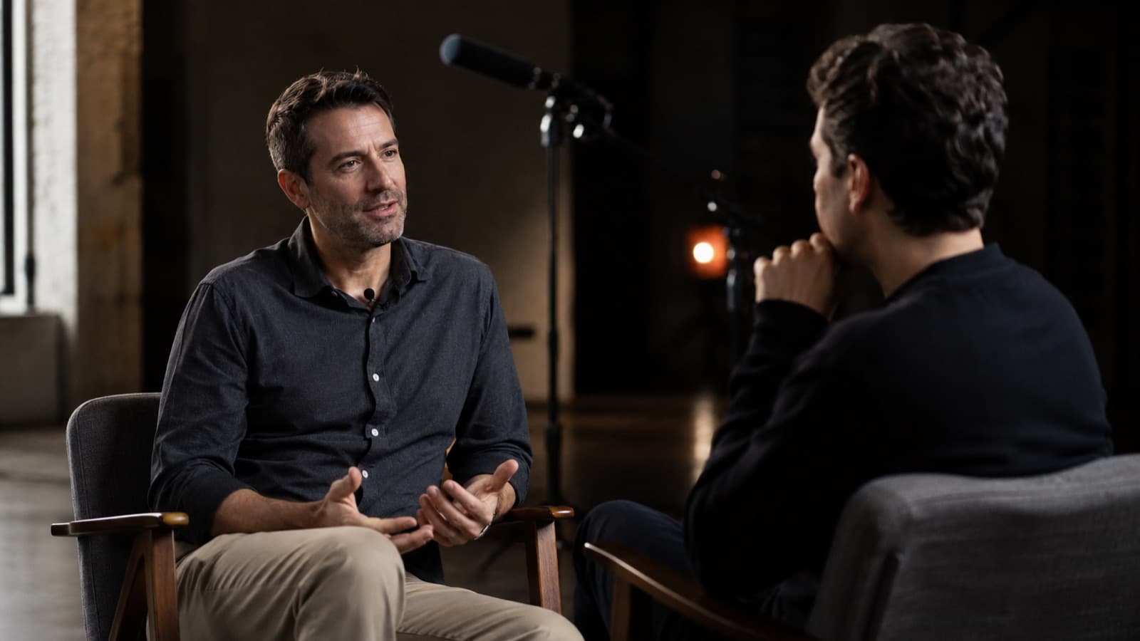Real interview scene with a shotgun microphone on a stand pointed at the interviewee