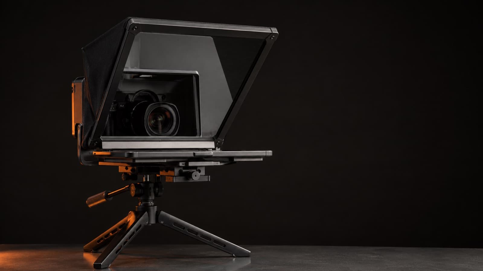 An all-in-one hardware teleprompter with the camera behind the glass, on a tabletop tripod